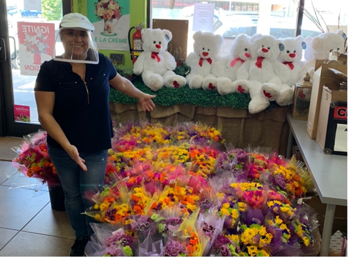 Romina Orozco-Encio with flower arrangements and gifts customers can buy or send to loved ones.