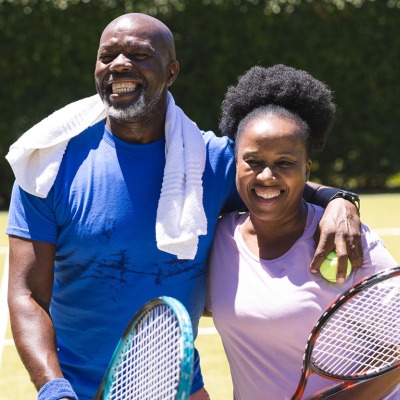 Couple posing with tennis equipment