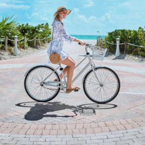Lady riding bike on the beachwalk