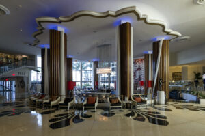 Interior view of the Eden Roc Hotel in Miami Beach, featuring Morris Lapidus’s signature mid-century modern design with bold columns, sweeping curves, and dramatic lighting.