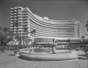 Black-and-white photograph of the Fontainebleau Hotel in Miami Beach, designed by architect Morris Lapidus in 1955, showcasing its signature curving façade and grand entrance fountain.