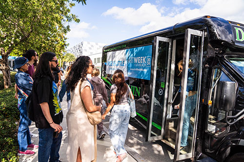 People boarding the shuttle bus for art week