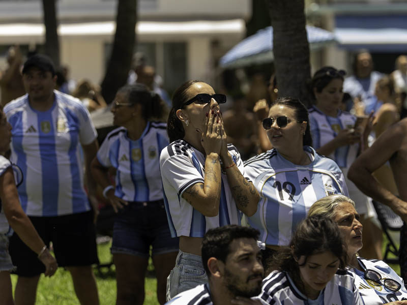 an Argentina fan in crowd with hands to her mouth looking anxious