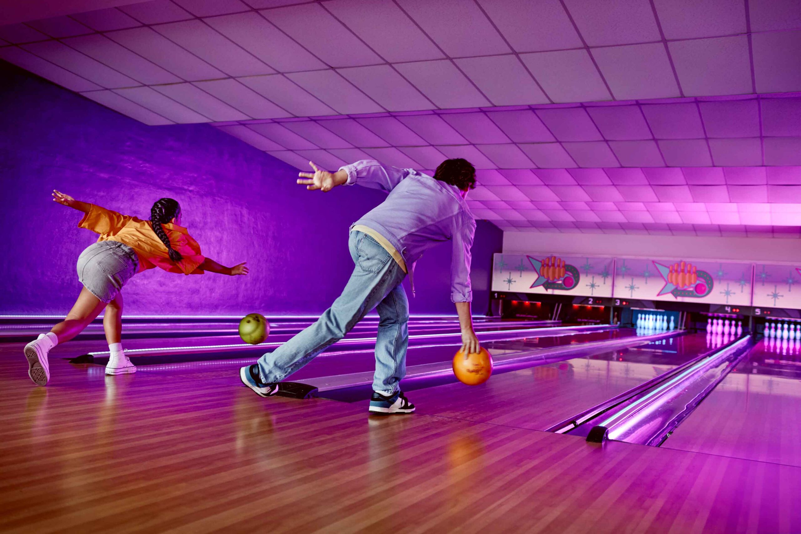 picture from the back of boy about to release bowling ball onto lane