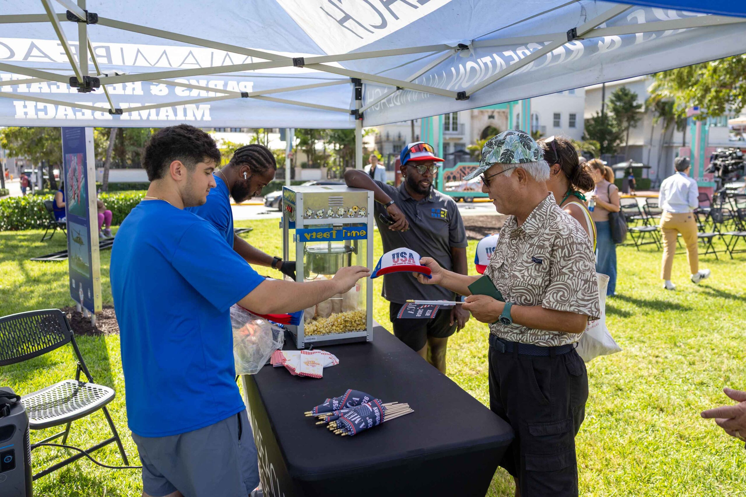 tent attendant handing USA hat to man