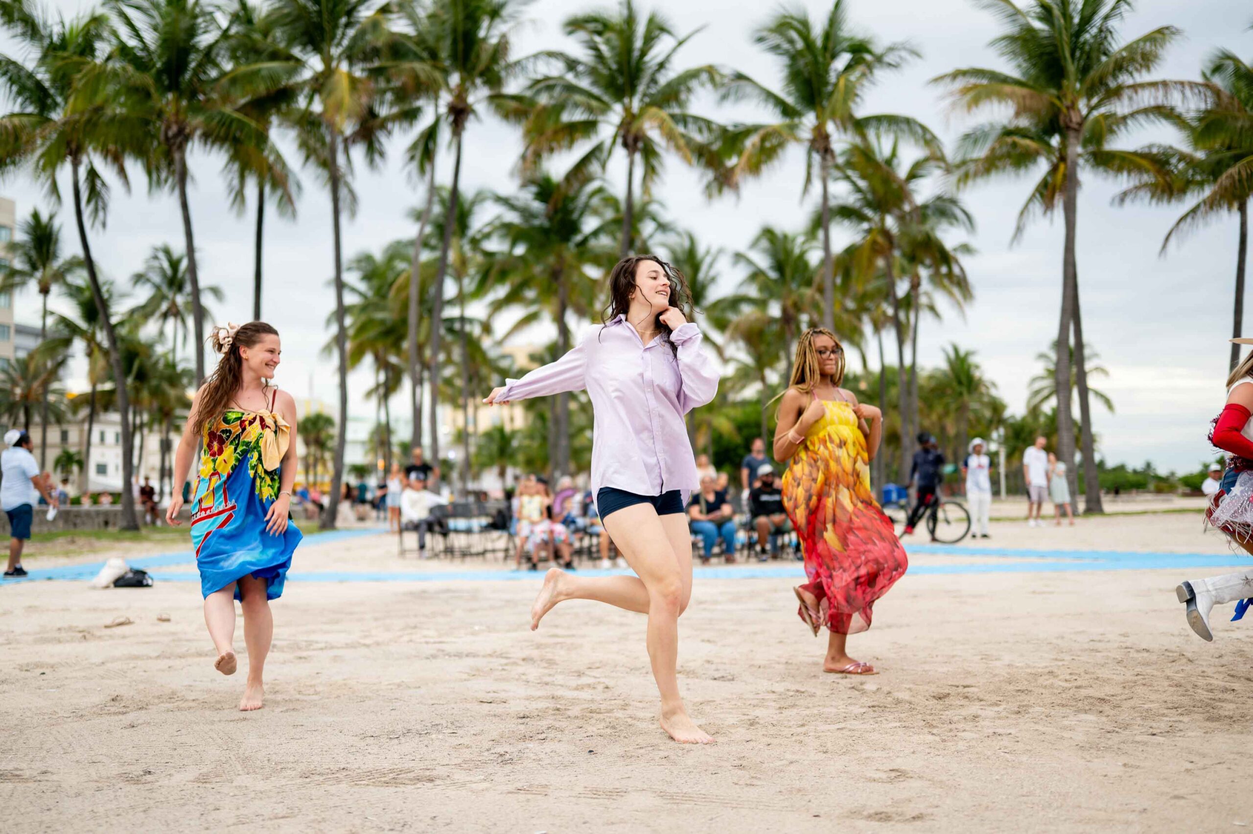 three women dancing on sand
