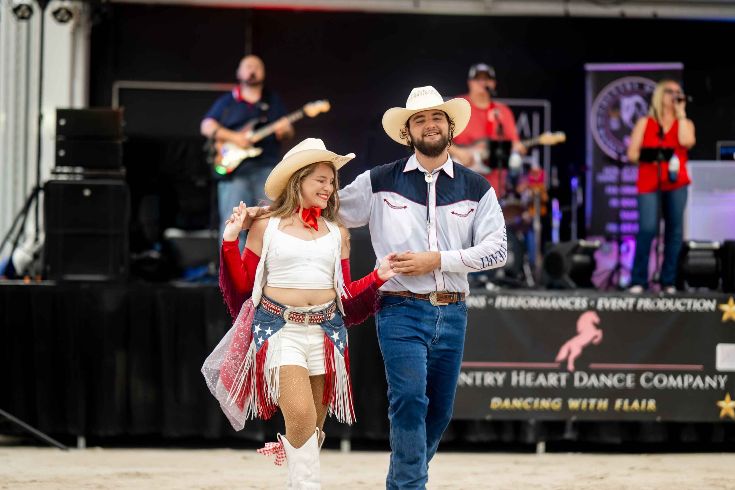 pair dancing with band on stage in background